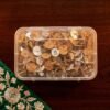 A clear plastic box filled with Meher Collections cork and cotton floating wicks on a dark wood surface.