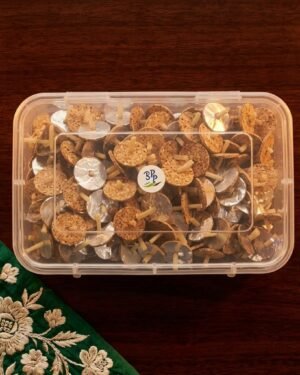A clear plastic box filled with Meher Collections cork and cotton floating wicks on a dark wood surface.